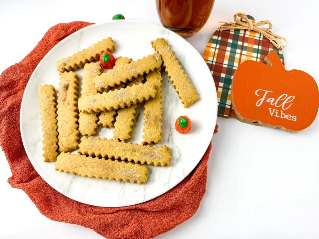 Pumpkin Spice Cookie Fries on a white plate with mini pumpkins next to a plaid hot pad