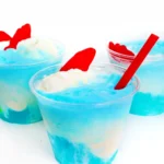 a seafoam ice cream float made with blue drink, vanilla ice cream and swedish fish