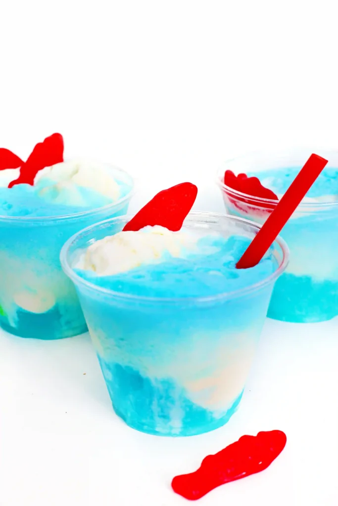 a seafoam ice cream float made with blue drink, vanilla ice cream and swedish fish