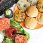 a halloween dinner idea with cheeseburgers that have ghost faces cut out of the cheese