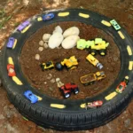 a tire raceway car race track for kids that uses an old tire with toy cars