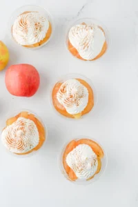 apple pie in a cup with a graham cracker crust, apple pie filling, and cool whip on top for these back to school snacks