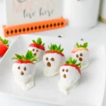 chocolate covered strawberry ghosts that are covered in white chocolate and have milk chocolate eyes and mouths