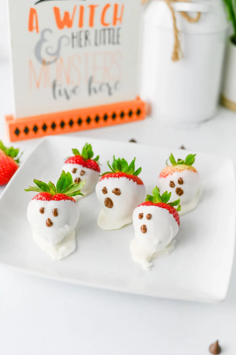 chocolate covered strawberry ghosts that are covered in white chocolate and have milk chocolate eyes and mouths