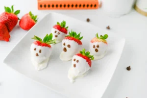chocolate covered strawberry ghosts that are covered in white chocolate and have milk chocolate eyes and mouths