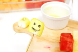 marshmallow dipped in yellow sanding sugar with a smiley face drawn on