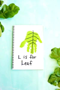 a letter L handprint craft that is a green handprint decorated to look like a leaf