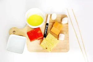 ingredients for the LEGO fruit skewers - pineapple, water,leon, cantaloup, marshmallow, yellow sanding sugar, black edible marker