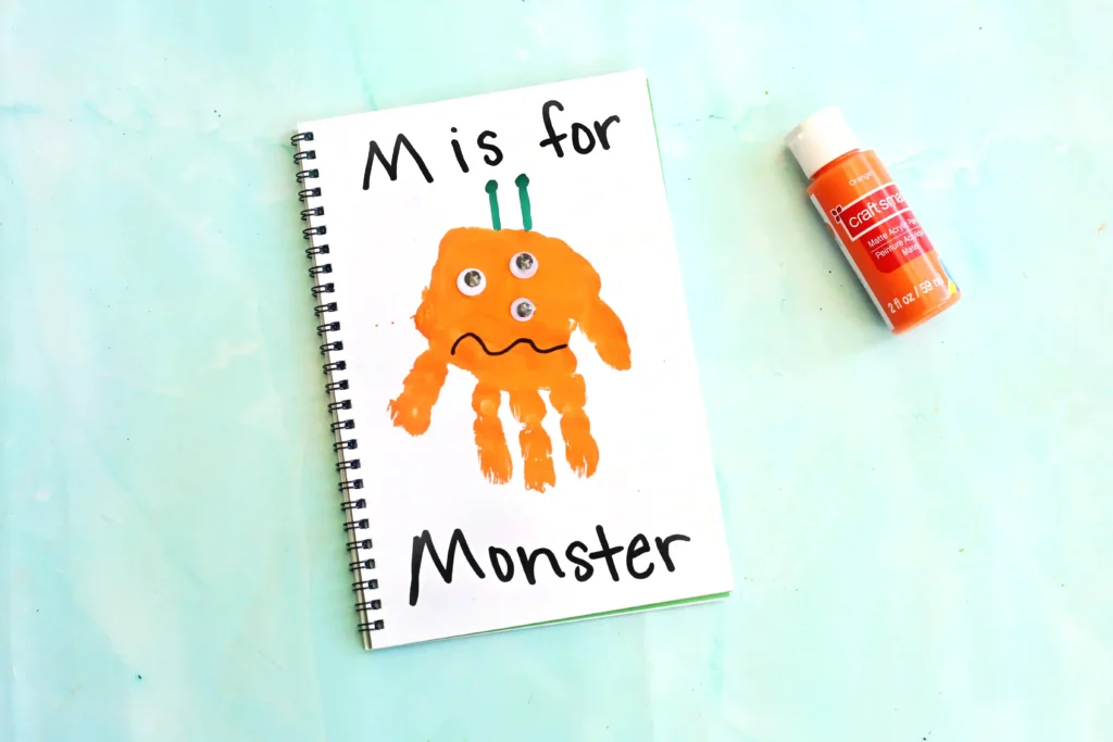 Letter M Handprint Craft - Cultivating Brilliant Minds a letter m handprint craft that is an orange handprint decorated to look like a monster with the words "M is for monster" written on the page