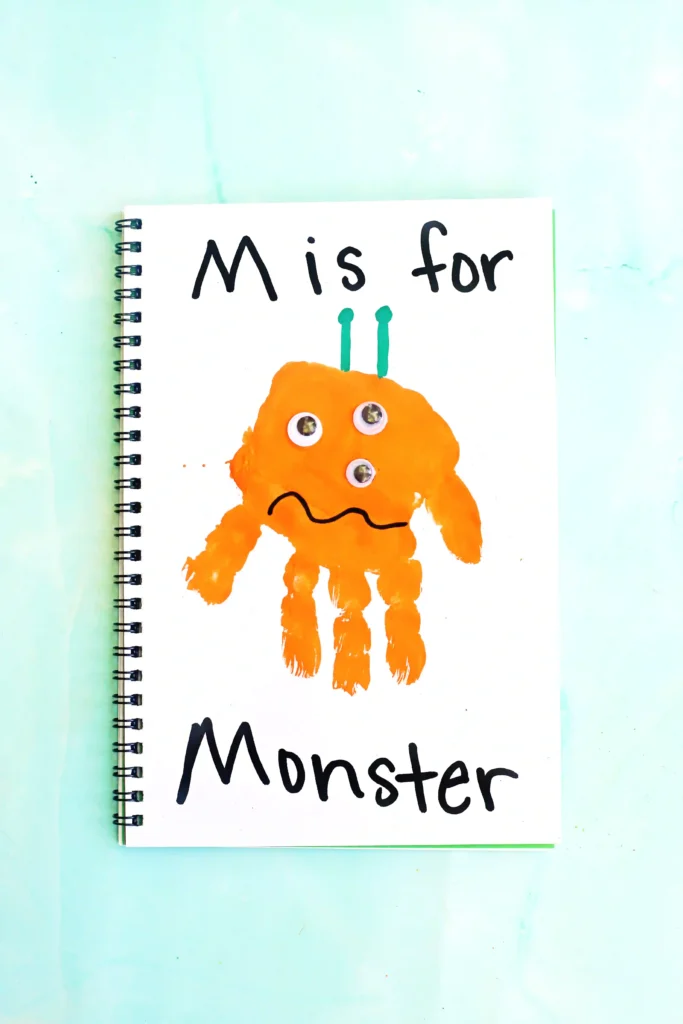Letter M Handprint Craft - Cultivating Brilliant Minds a letter m handprint craft that is an orange handprint decorated to look like a monster with the words "M is for monster" written on the page