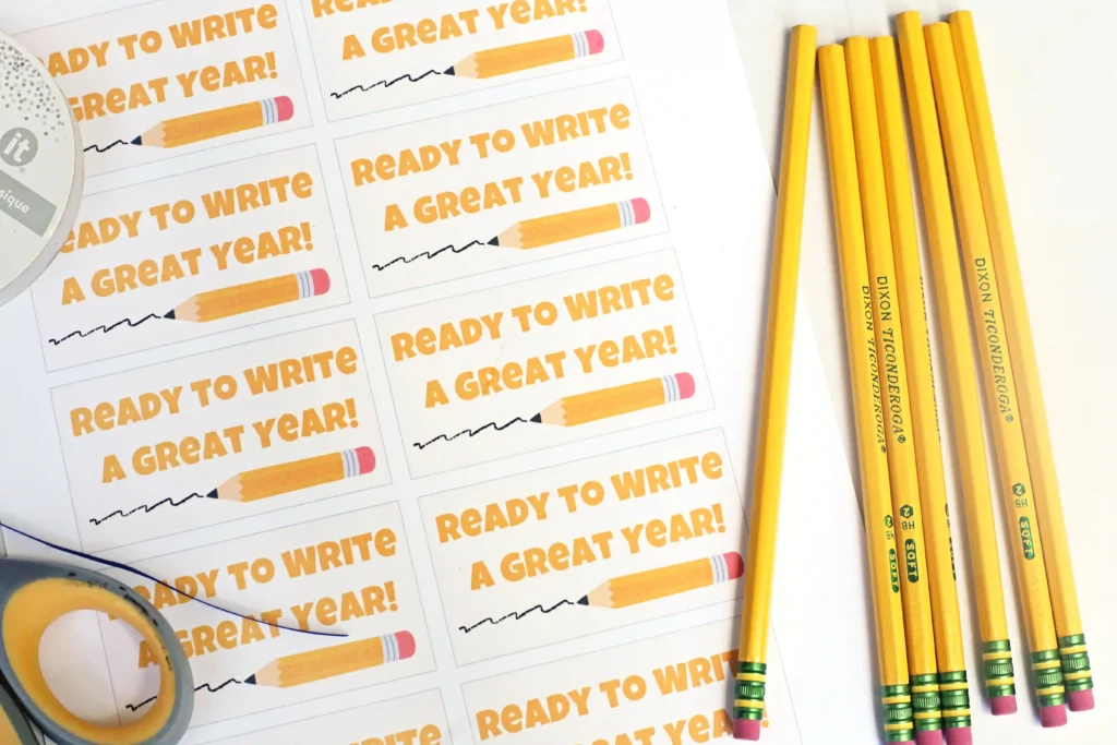 Desk with multiple cards reading'Ready to Write A Great Year!' and a row of yellow pencils on the right side.