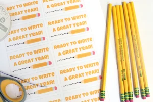 Desk with multiple cards reading 'Ready to Write A Great Year!' and a row of yellow pencils on the right side.