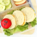 a Very Hungry Caterpillar Lunch Box Idea that us sandwiches and babybel cheese on a bed of lettuce to look like a caterpillar