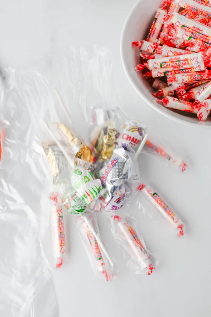 Halloween Treat Bags - Cultivating Brilliant Minds a clear plastic glove filled with halloween candy