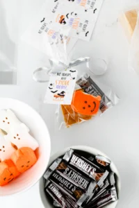Halloween-themed treat assortment: pumpkin-faced peeps, Hershey's bars, graham crackers and gift tags reading 'No tricks, just S’more treats'.