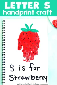 a red handprint decorated to look like a strawberry with the words "s is for strawberry"