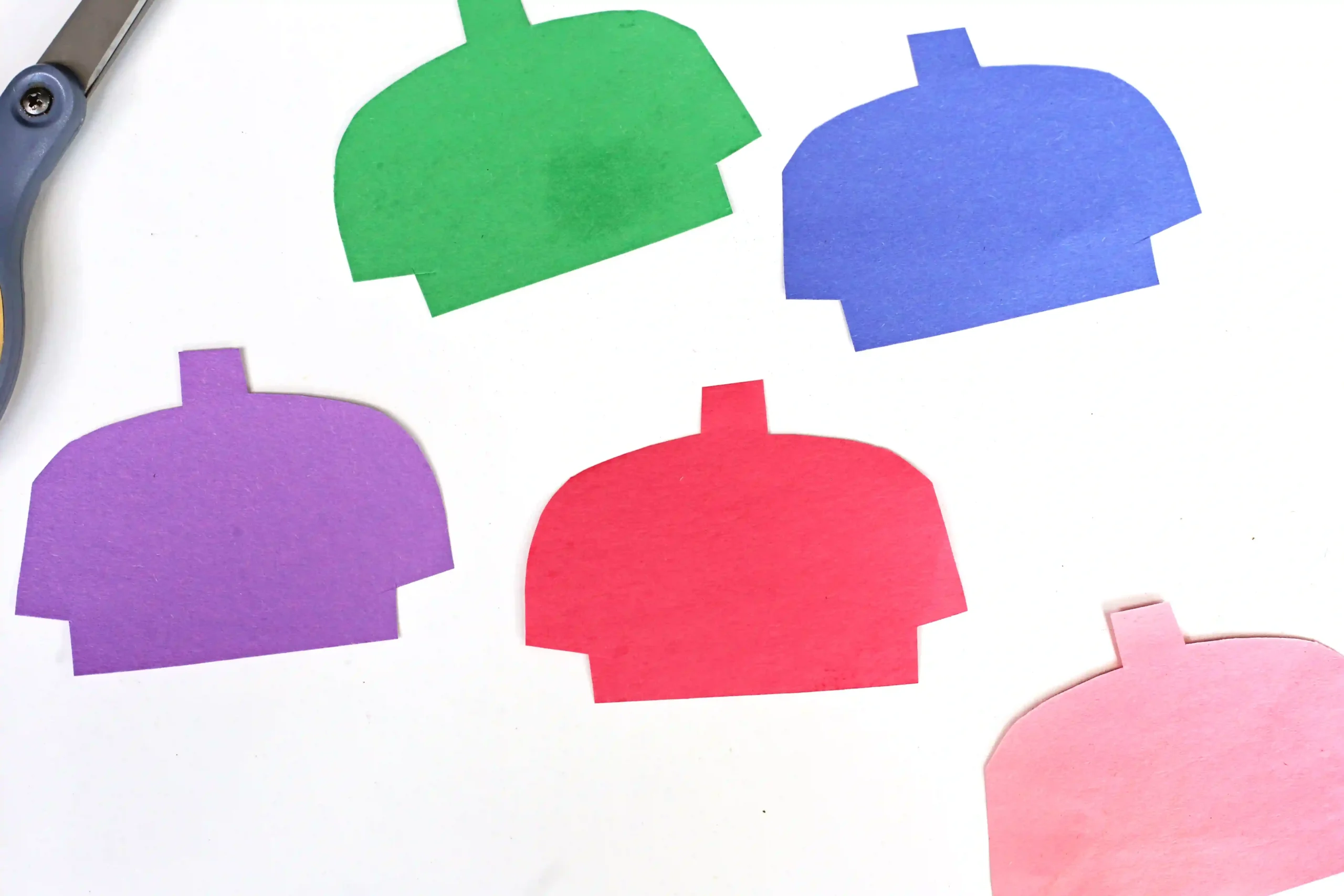 LEGO Minifigures - Cultivating Brilliant Minds Assorted colorful paper cutouts in human-shape silhouettes on a white surface.