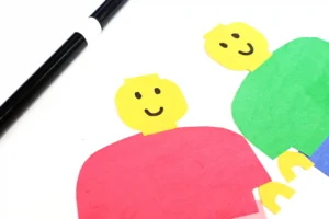 a lego person made out of construction paper with a smiley face