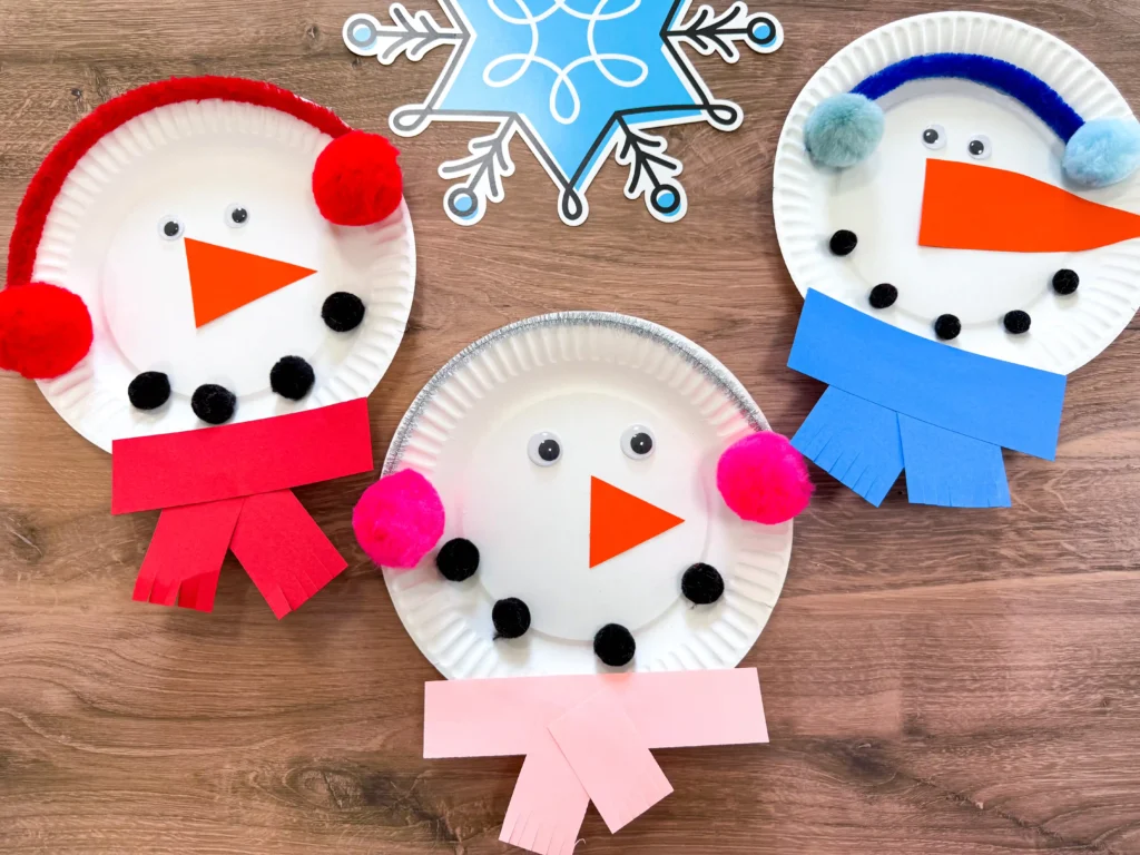 Paper Plate Snowman Craft - Cultivating Brilliant Minds paper plates decorated to look like snowmen with earmuffs and scarves