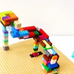 Colorful LEGO brick structure built on a tan baseplate against a white background.