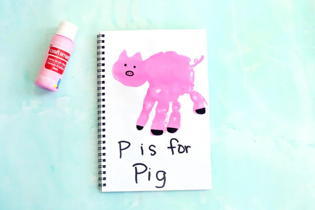 a letter p handprint craft of a pink handprint decorated to look like a pig