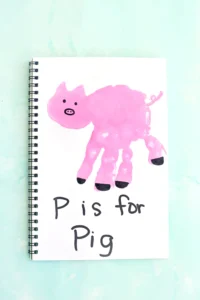 a letter p handprint craft of a pink handprint decorated to look like a pig