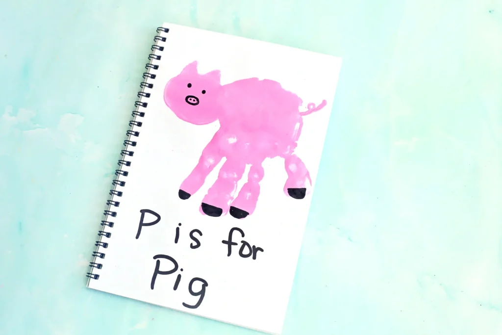 a letter p handprint craft of a pink handprint decorated to look like a pig