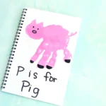 a letter p handprint craft of a pink handprint decorated to look like a pig