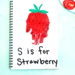 a red handprint decorated to look like a strawberry with the words "s is for strawberry"