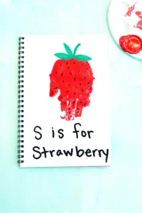 a red handprint decorated to look like a strawberry with the words "s is for strawberry"