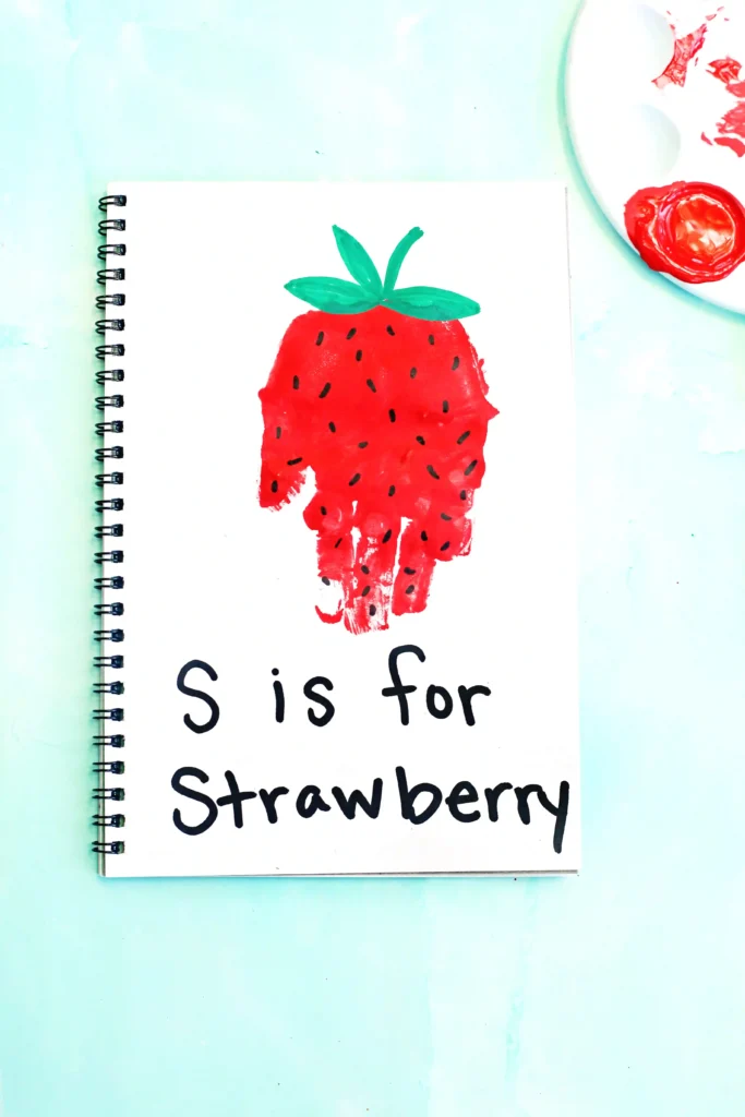 a red handprint decorated to look like a strawberry with the words "s is for strawberry"