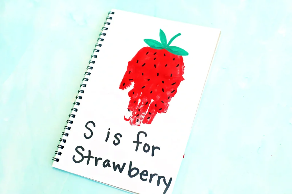a red handprint decorated to look like a strawberry with the words "s is for strawberry"