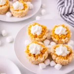 Mini Pumpkin Pie Rice Krispies with whipped cream on top on a white plate