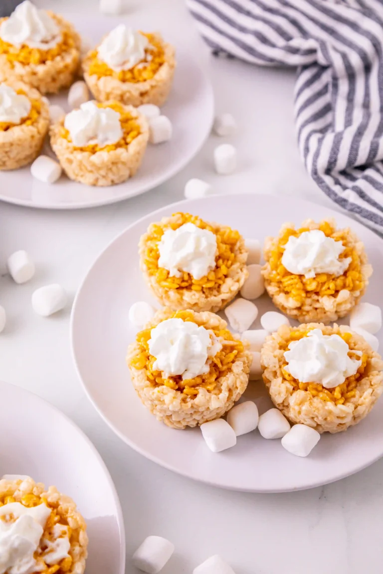 Mini Pumpkin Pie Rice Krispies with whipped cream on top on a white plate