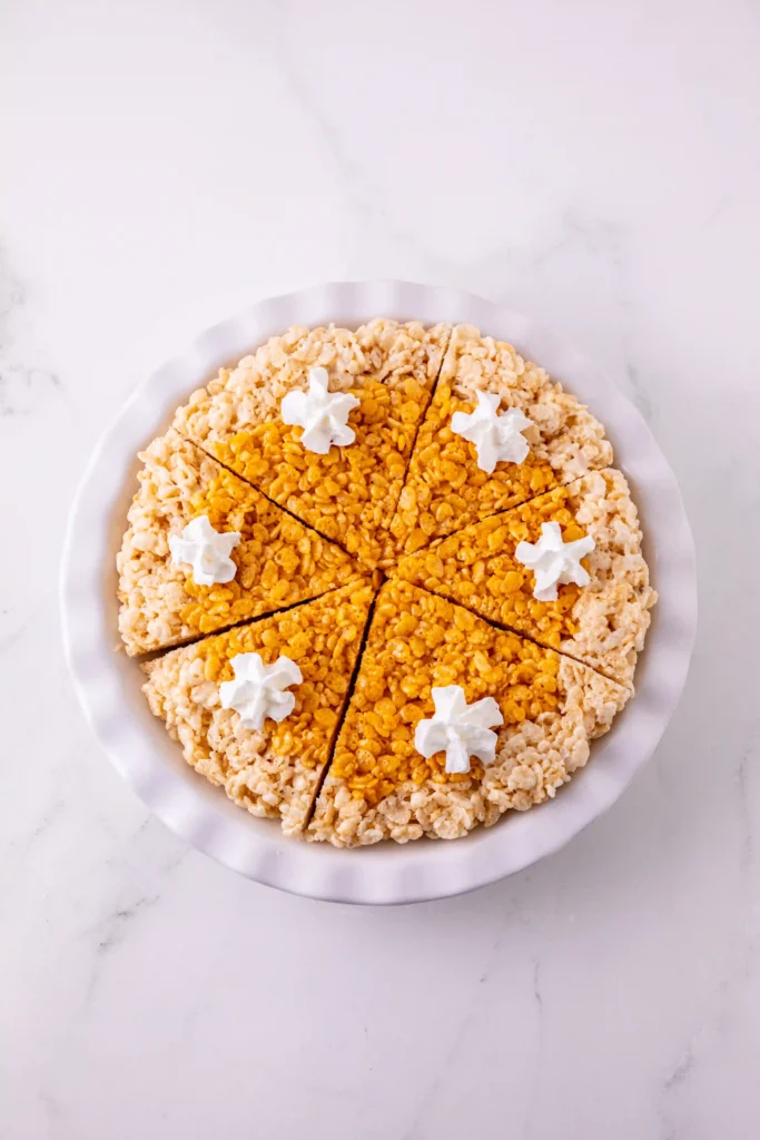 rice krispie treats made into a pumpkin pie with whipped cream on top