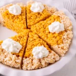 rice krispie treats made into a pumpkin pie with whipped cream on top