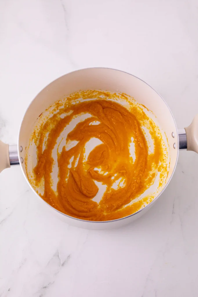 pumpkin puree, pumpkin spice, and butter cooking in a pan