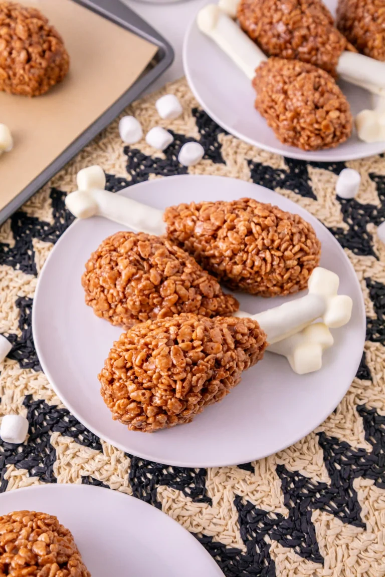 Rice Krispie Turkey Legs on a white plate with other rice krispie turkey legs in the background