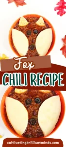 a bowl of chili with crackers and olives on top to look like a fox