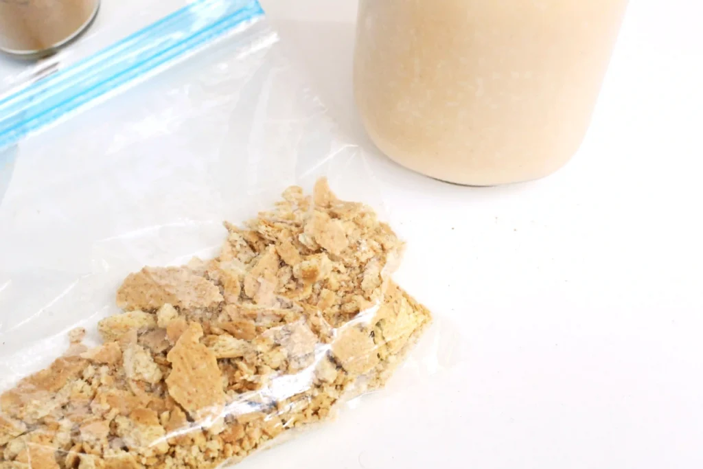 Crumbled graham crackers in a bag on a white surface