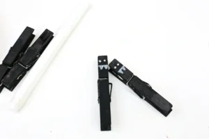 Close-up of black binder clips with white face drawings on a white surface.