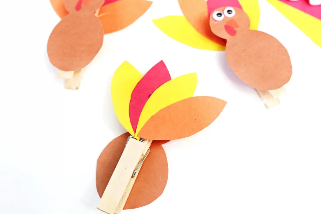 construction paper feathers glued to the back of a clothespin