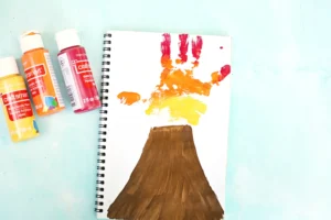 Notebook page with a colorful orange-red-yellow handprint volcano