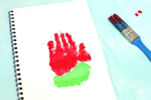 White spiral notebook with a red and green handprint to look like a watermelon