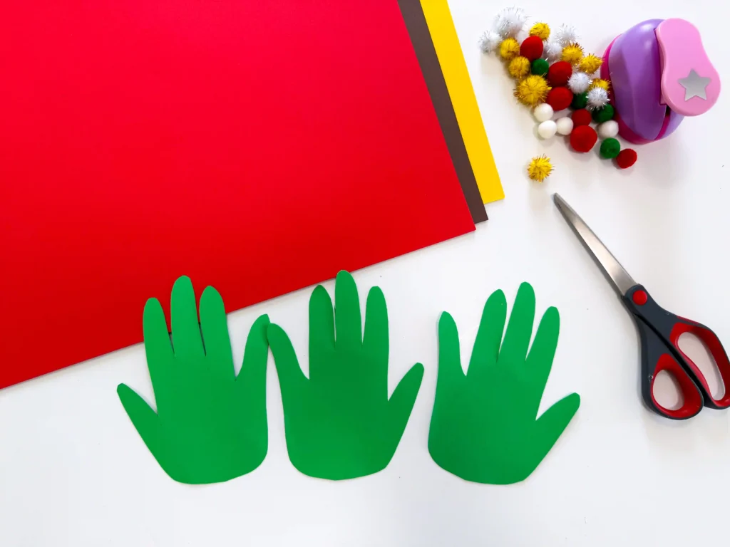 3 handprints cut out of green construction paper