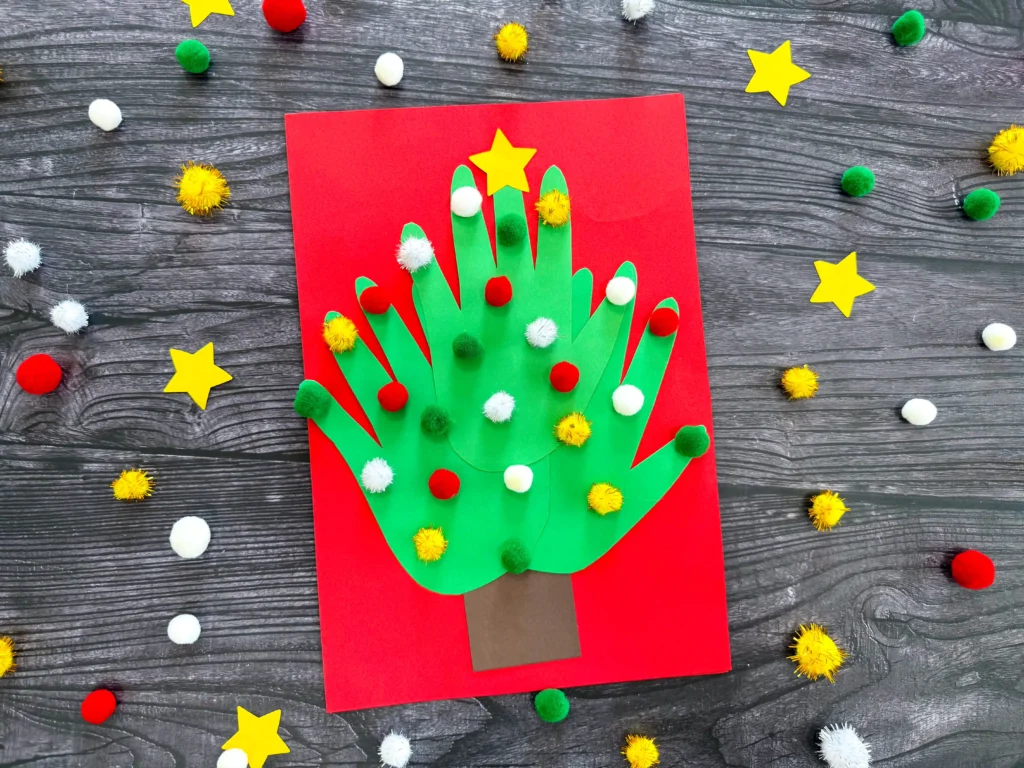 a Handprint Tree Christmas Card made of construction paper handprints and pom poms