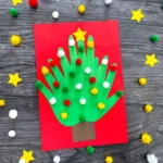 a Handprint Tree Christmas Card made of construction paper handprints and pom poms