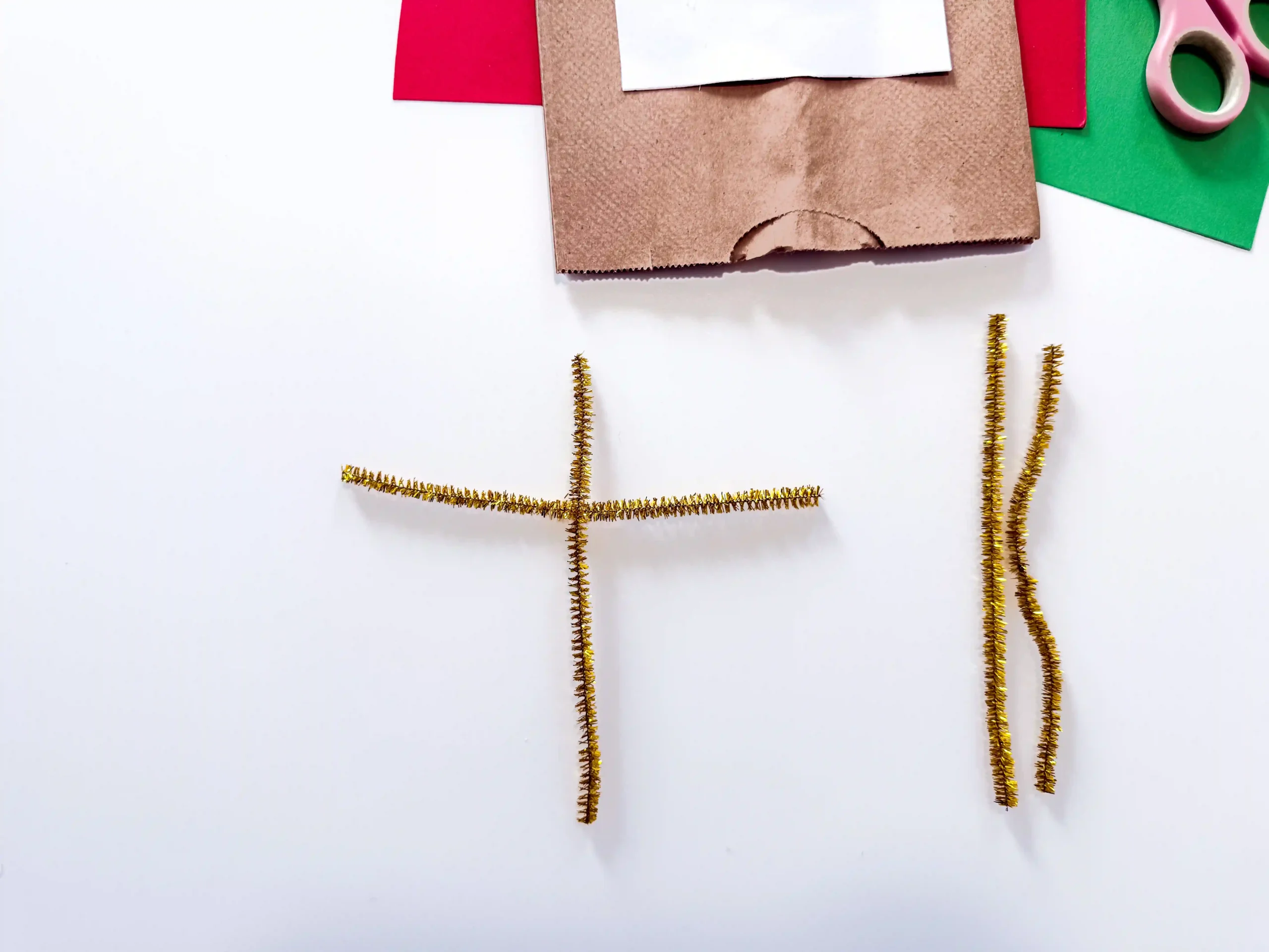 two gold pipe cleaners in the shape of a T