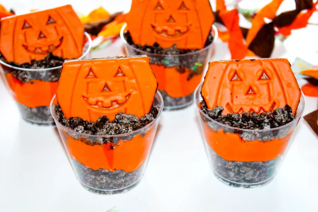 Halloween Dirt cups with crushed oreos, orange dyed pudding, and little debbie pumpkin brownies