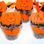 Halloween Dirt cups with crushed oreos, orange dyed pudding, and little debbie pumpkin brownies